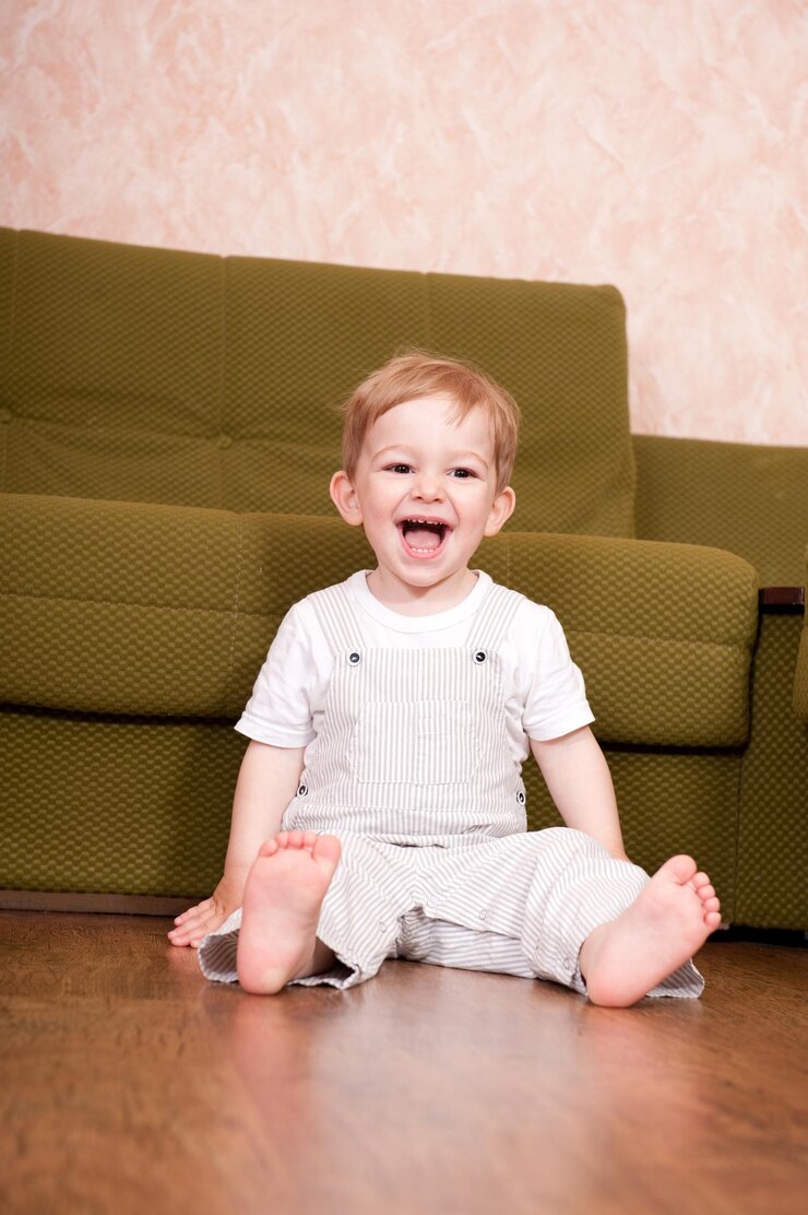 Foto retrato de um menino sorridente sentado no sofá