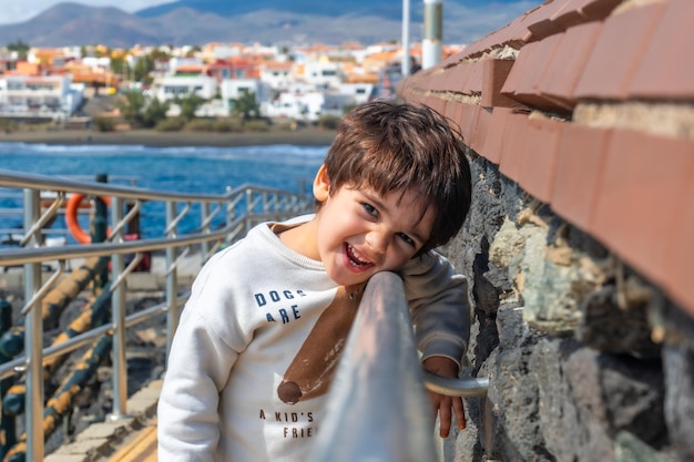 Retrato de um menino sorrindo nas férias de verão à beira-mar