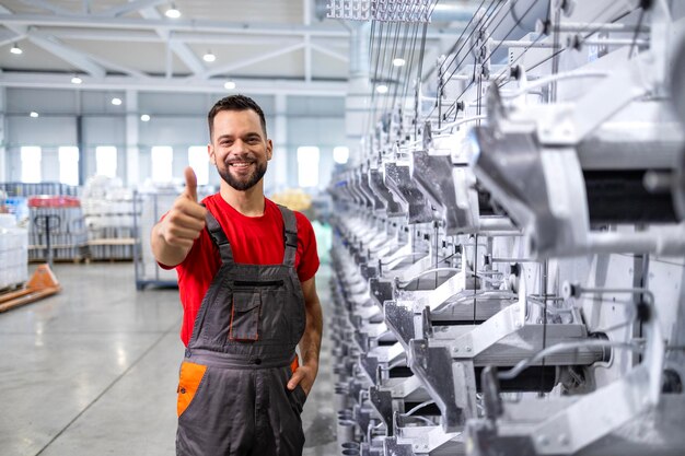 Foto retrato de um militar de engenharia de pé junto à máquina da linha de produção dentro da fábrica