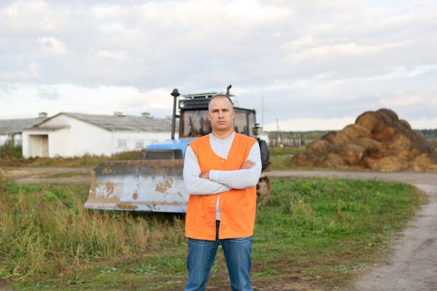 Retrato de um motorista de escavadeira contra fazenda