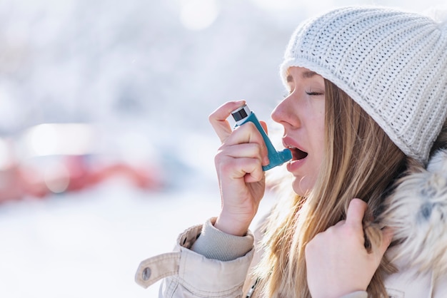 Retrato, de, um, mulher, usando, um, inalador asma, em, um, inverno frio