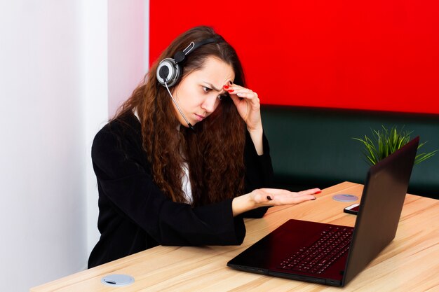 Retrato de um operador feminino em um computador em um escritório.