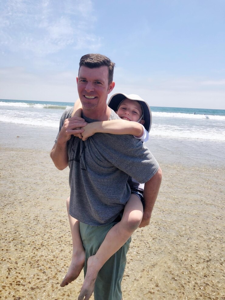 Foto retrato de um pai carregando a filha de volta na praia