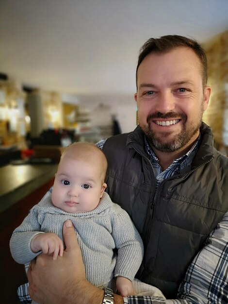 Foto retrato de um pai carregando seu filho