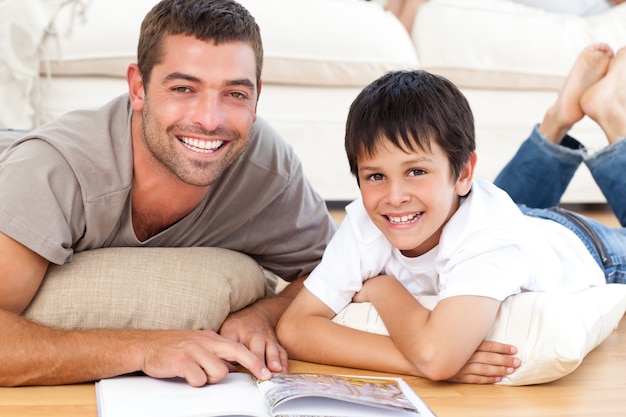 Retrato de um pai e filho, lendo um livro juntos no chão