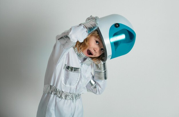 Foto retrato de um pequeno astronauta maravilhado com capacete e traje espacial protetor um pequeno astrônomo engraçado