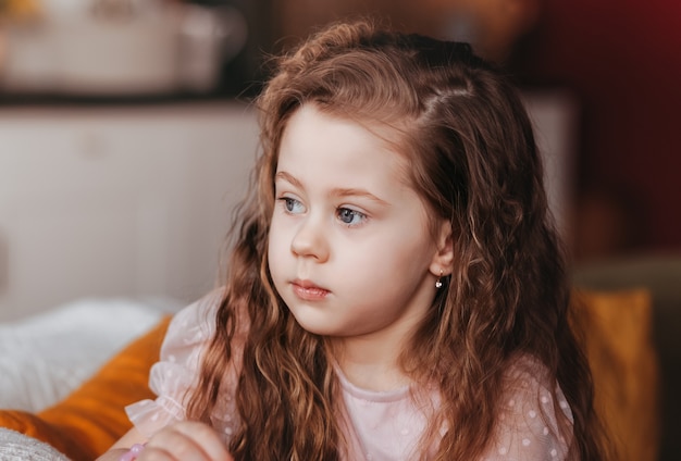 Retrato de um pequeno close-up de menina sonhadora. sem olhar para a câmera.