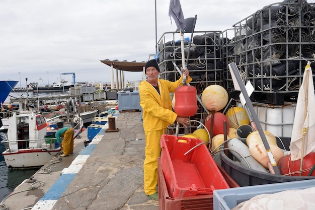 Retrato de um pescador no porto pegando uma bóia de espinhel