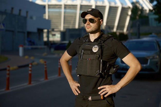 Retrato de um policial de patrulha confiante de pé ao ar livre