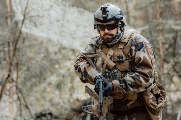 Retrato de um soldado barbudo de meia idade em um uniforme militar da floresta e capacete com fones de ouvido