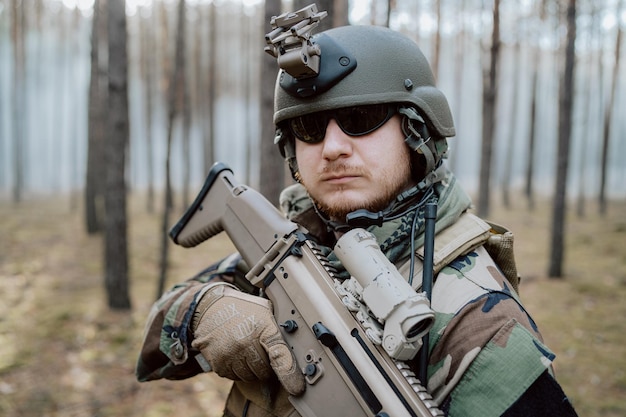 Retrato de um soldado barbudo de meia idade em um uniforme militar da floresta e capacete com fones de ouvido