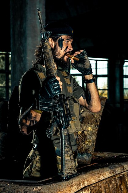 Foto retrato de um soldado segurando uma arma no edifício