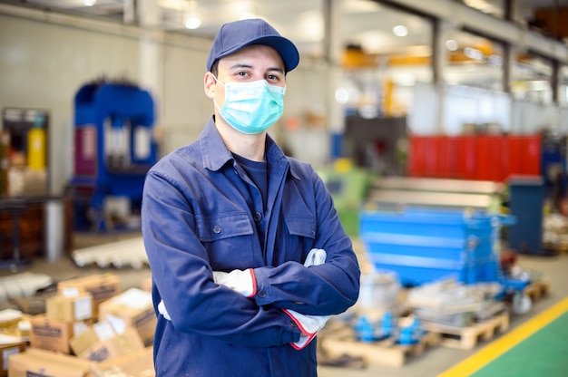 Retrato de um trabalhador em uma planta industrial usando uma máscara, conceito de coronavírus