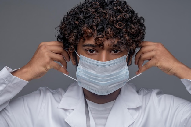 Retrato de um trabalhador médico com um jaleco e uma máscara protetora descartável