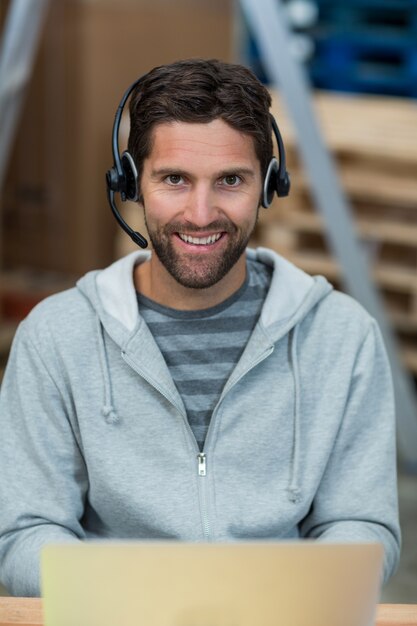 Retrato de um trabalhador sorridente usando um fone de ouvido