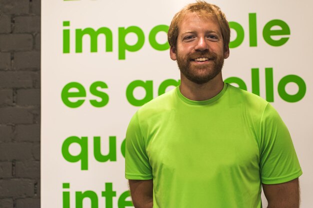Foto retrato de um treinador pessoal roxo sorridente com uma camiseta verde