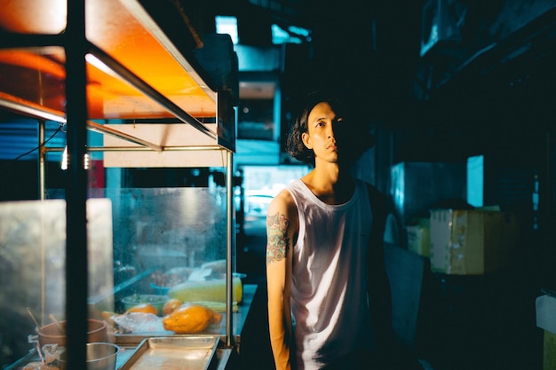 Retrato de um vendedor de pé à noite