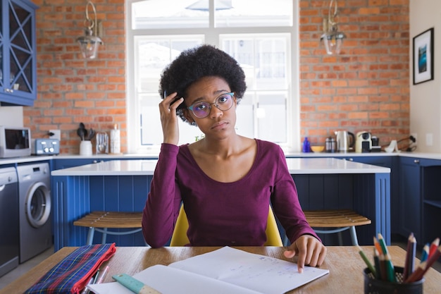 Retrato de uma adolescente afro-americana tensa estudando em casa