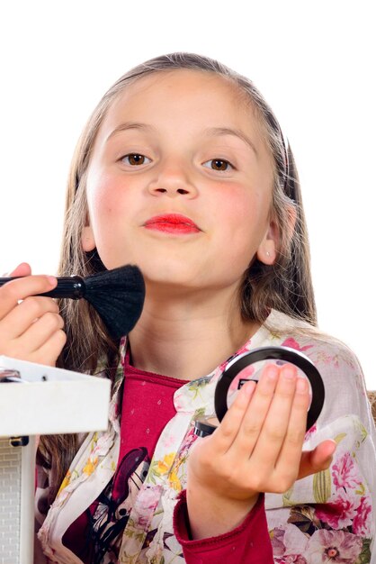 Foto retrato de uma adolescente aplicando maquiagem contra um fundo branco