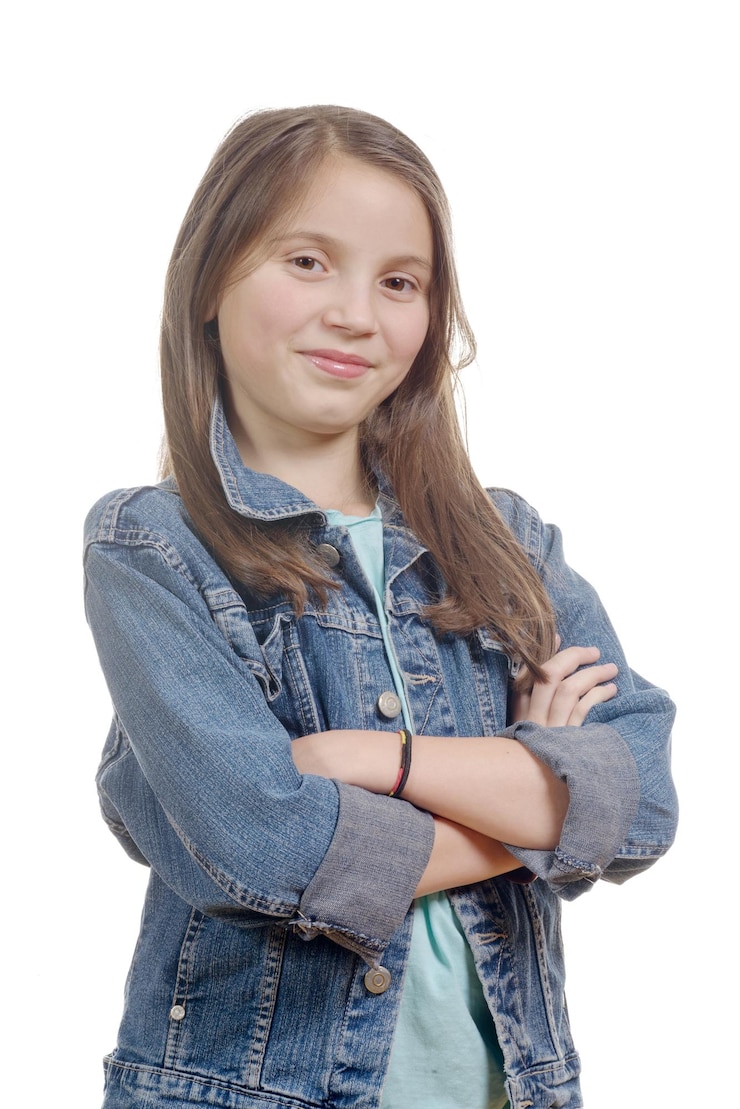 Foto retrato de uma adolescente com os braços cruzados de pé contra um fundo branco