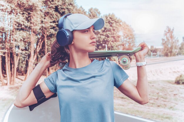 Retrato de uma adolescente com um skate. Conceito de estilo de vida esportivo.