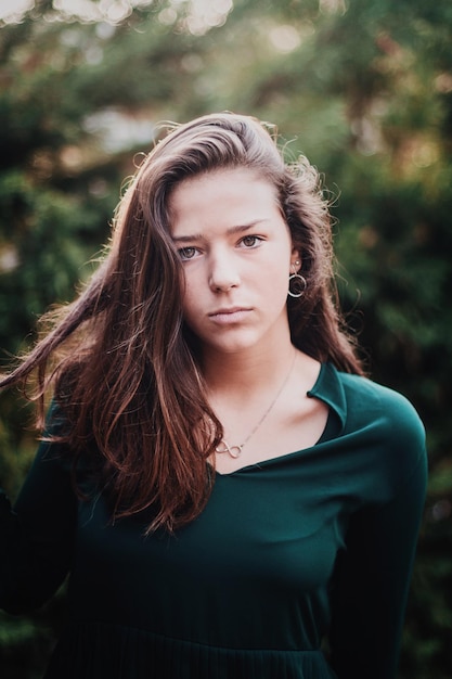 Retrato de uma adolescente de pé contra plantas