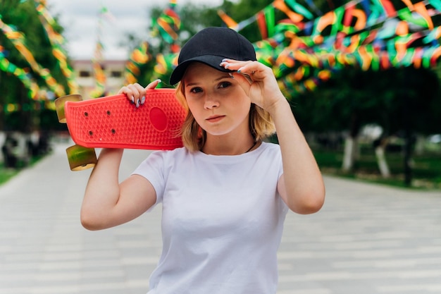 Retrato de uma adolescente em roupas casuais Estilo de vida ativo de skate de verão Um estudante ou um estudante nas férias de verão Atividades esportivas