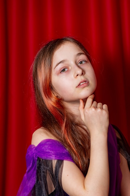 Foto retrato de uma adolescente em roxo com um vestido preto. arte, posar de modelo.