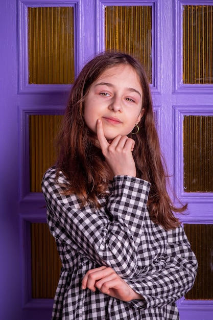 Foto retrato de uma adolescente em um vestido em uma gaiola. uma garota de cabelos loiros.