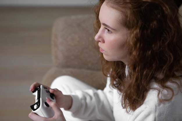 Retrato de uma adolescente Geração Z jogando videogame em casa em um console