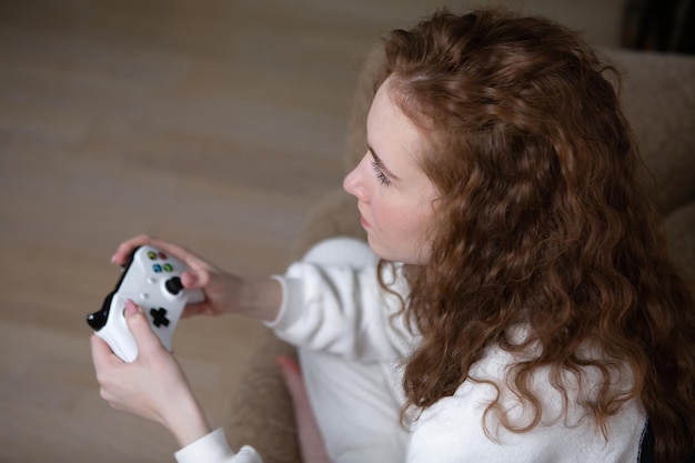 Retrato de uma adolescente Geração Z jogando videogame em casa em um console