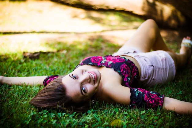 Retrato de uma adolescente sorridente deitada na grama