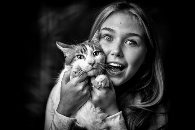 Foto retrato de uma adolescente sorridente segurando um gato