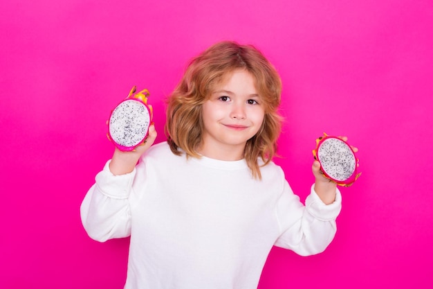 Retrato de uma adolescente usando luvas de malha e suéter de inverno brincando com bola de Natal isolada em fundo de estúdio amarelo