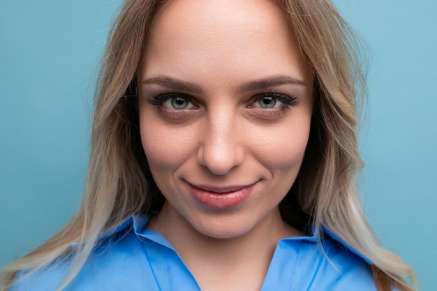 Retrato de uma adorável jovem loira fechando os olhos de forma fofa sobre um fundo azul