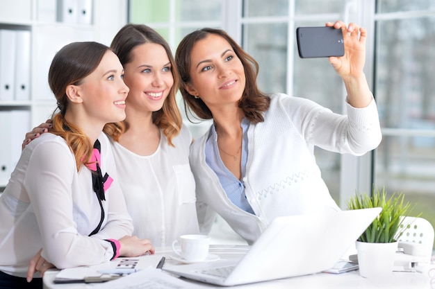 Retrato de uma agradável mulher de negócios com um telefone no escritório