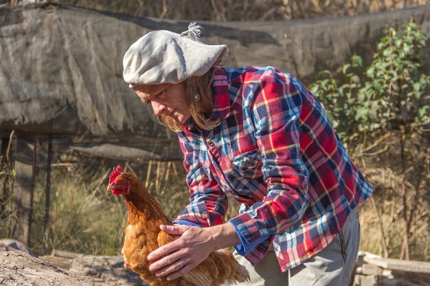 Retrato de uma agricultora argentina com uma galinha