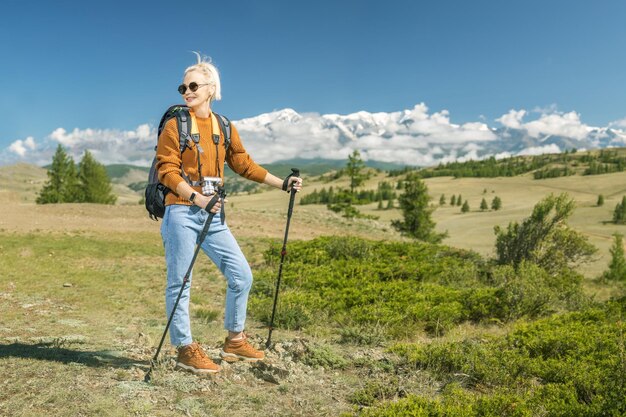 Retrato de uma alpinista sorridente feliz parada na encosta da montanha viagens e conceito de estilo de vida ativo