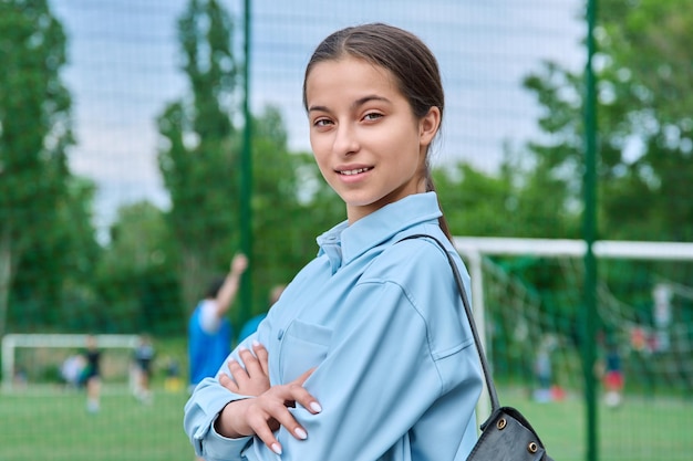 Retrato de uma aluna adolescente olhando para o fundo do estádio da escola de câmeras