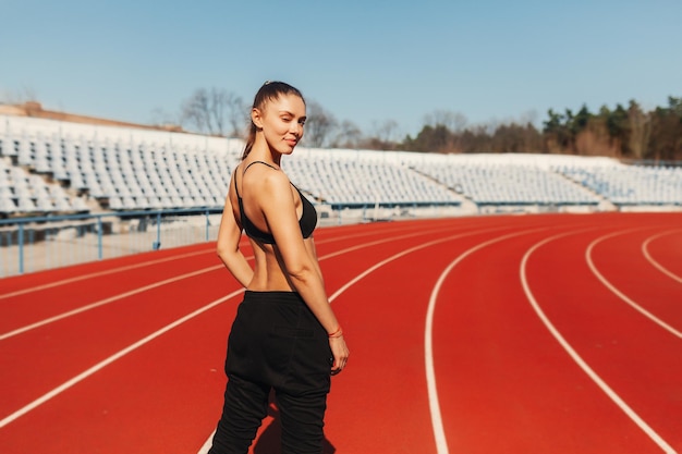 Retrato de uma atleta de pé na pista de corrida