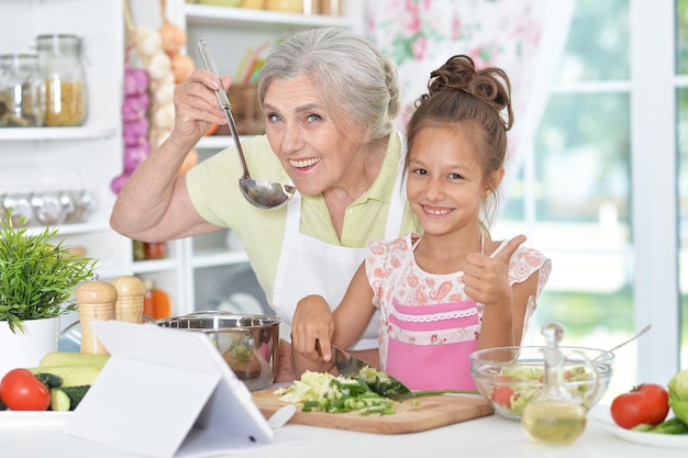Retrato de uma avó e neta preparando o jantar