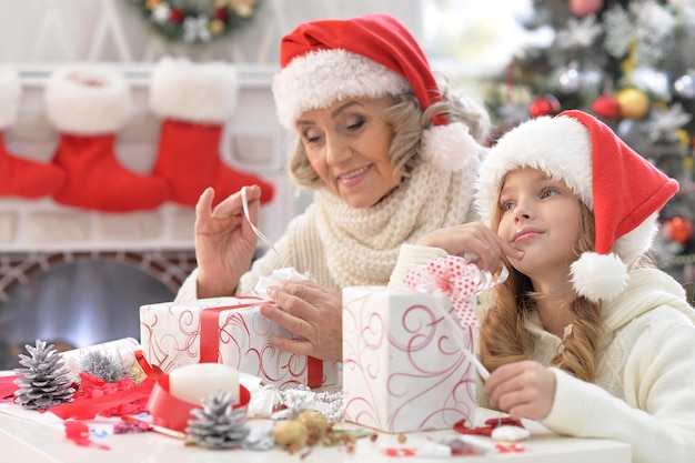 Retrato de uma avó feliz e sua netinha se preparando para o Natal juntos em casa