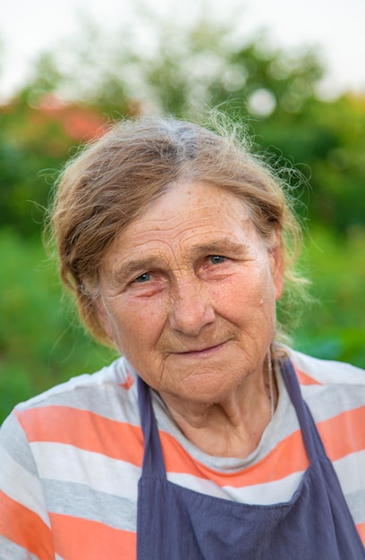 Retrato de uma avó no foco seletivo do jardim