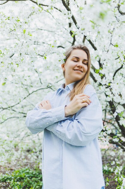 Retrato de uma bela dama romântica em flores de macieiras