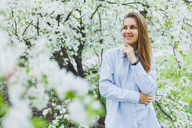 Retrato de uma bela dama romântica em flores de macieiras