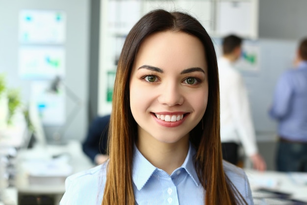 Retrato de uma bela e alegre empresária emocionalmente feliz no fundo do colega de trabalho