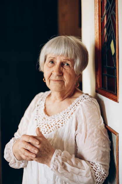 Retrato de uma bela idosa fotografada em sua casa onde mora sozinha