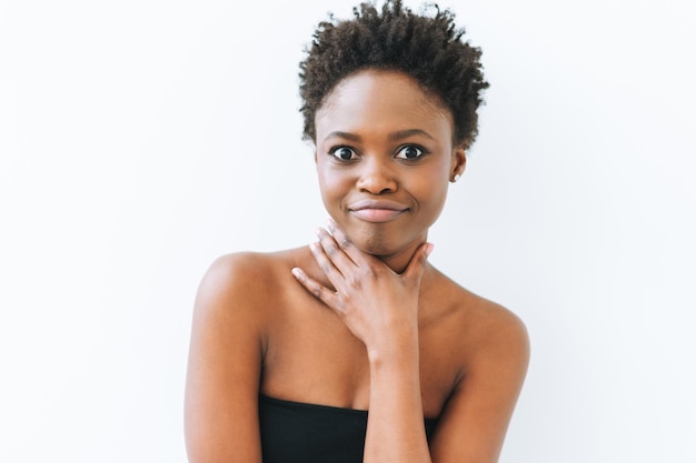 Retrato de uma bela jovem afro-americana sorridente no topo preto isolado no fundo branco