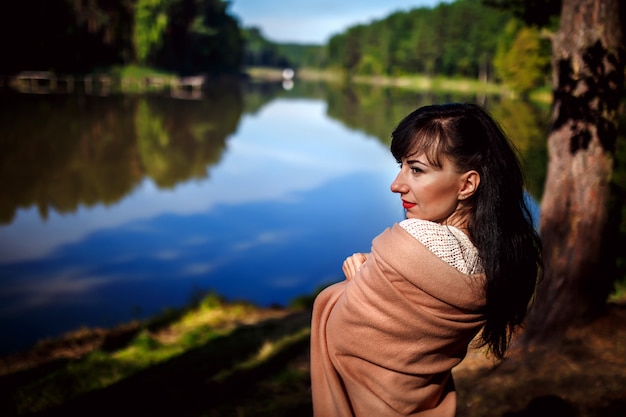 Retrato de uma bela jovem ao ar livre perto do lago