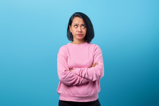 Retrato de uma bela jovem asiática com braços cruzados e expressão infeliz